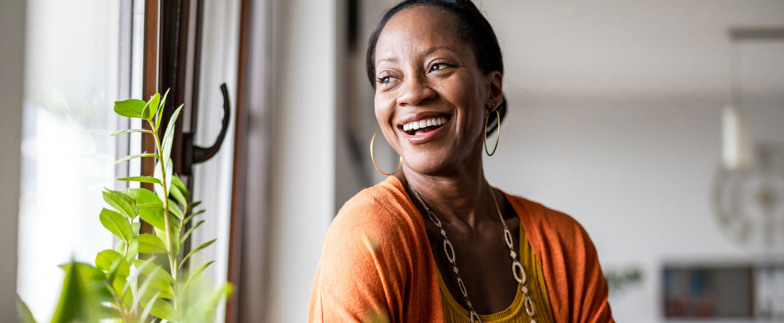 A woman smiling and looking out a window